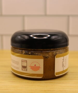 Jar of Turmeric Dark Spot Scrub with golden yellow hue, featuring botanical ingredients like turmeric root, papaya, and licorice—ideal for hyperpigmentation and skin brightening.
